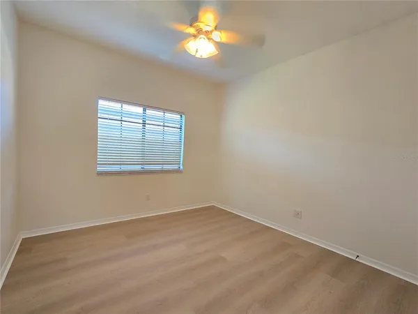 an empty room with a window and a fan