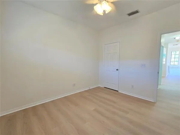 an empty room with a chandelier fan