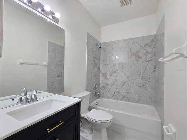 a bathroom with a bathtub a sink a toilet and a mirror