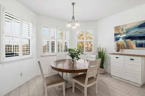a dining room with furniture a chandelier and wooden floor
