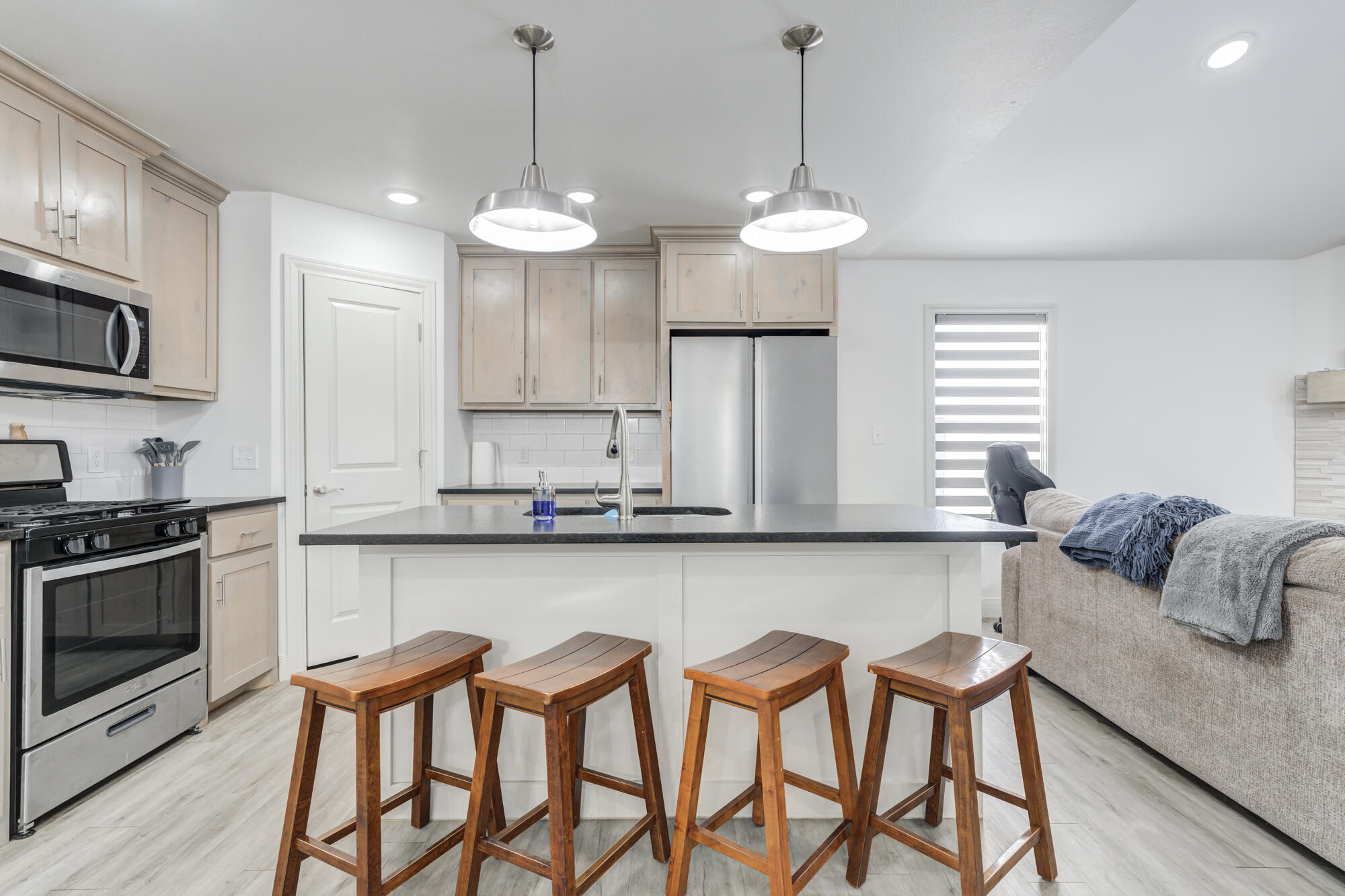 7020 24th Street Lubbock, TX 79407 - Photo 13 of 31 a kitchen with stainless steel appliances granite countertop a stove top oven a sink a dining table and chairs with wooden floor