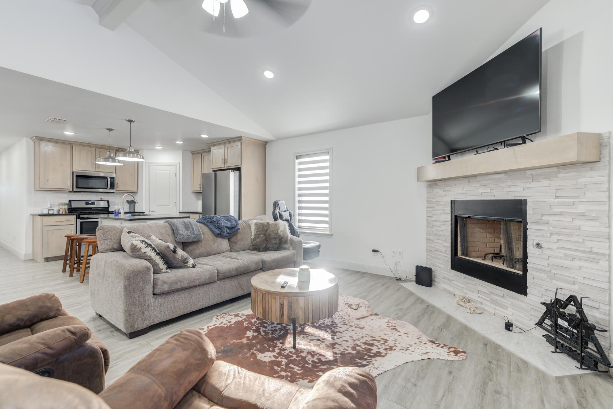 7020 24th Street Lubbock, TX 79407 - Photo 2 of 31 a living room with furniture a flat screen tv and a fireplace