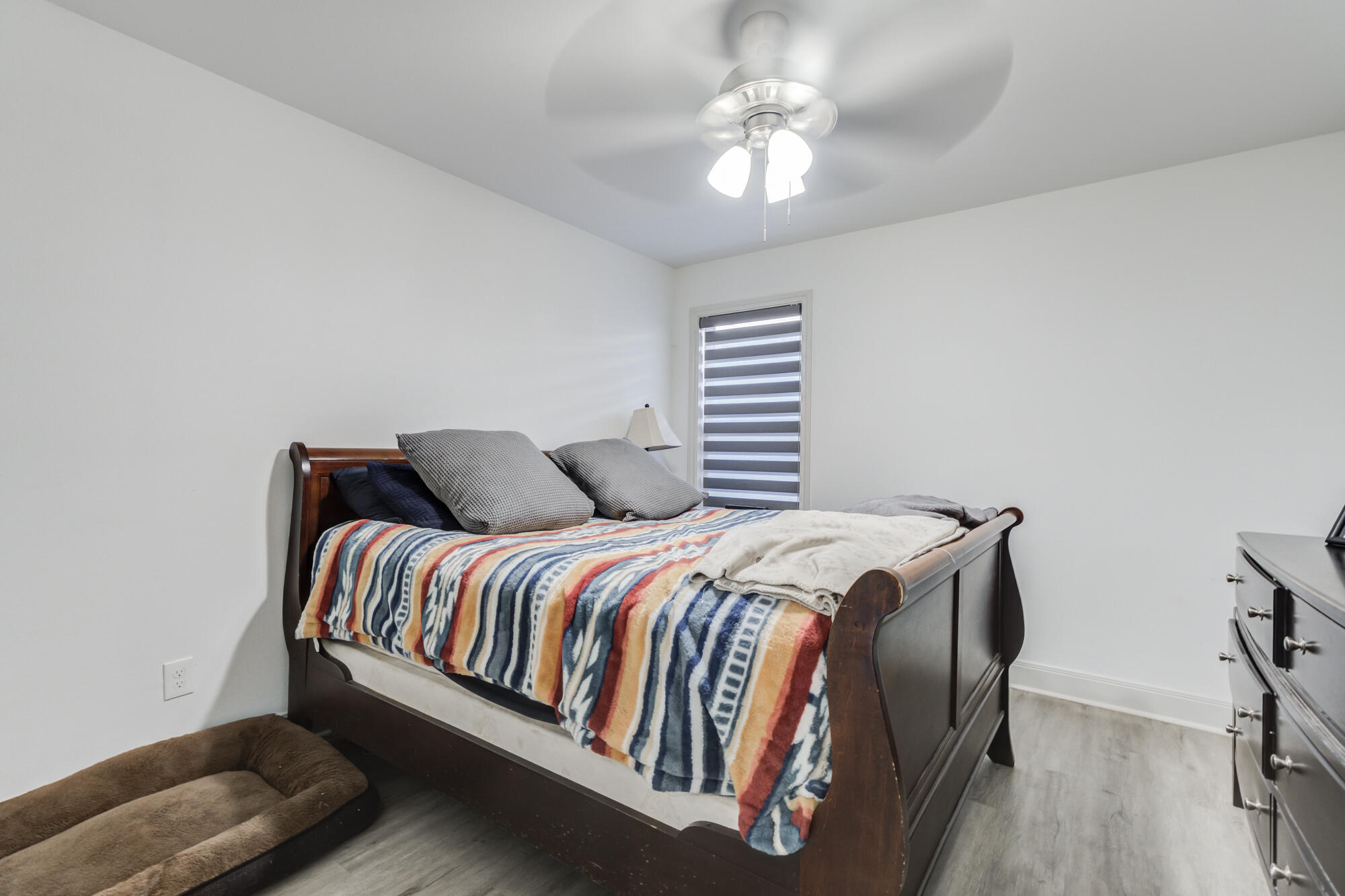 7020 24th Street Lubbock, TX 79407 - Photo 23 of 31 a bedroom with a bed and a chandelier