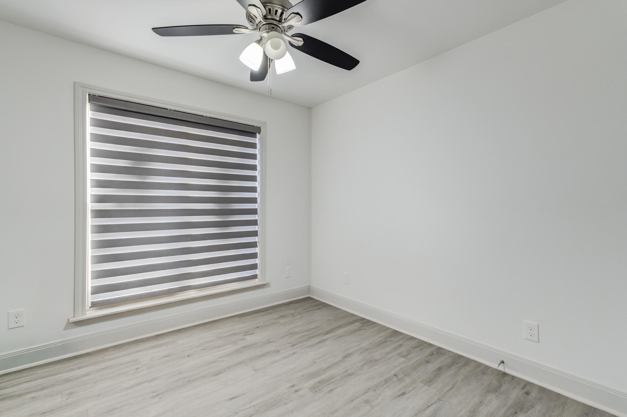 7020 24th Street Lubbock, TX 79407 - Photo 29 of 31 a view of an empty room with a window and wooden floor