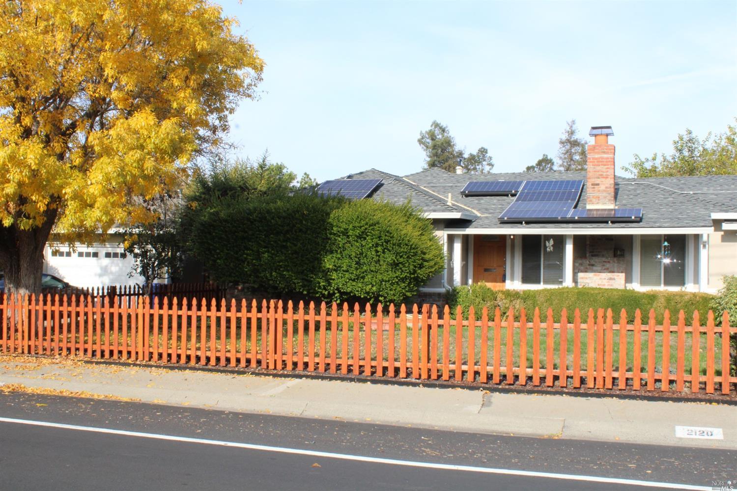a view of a house with a wooden fence