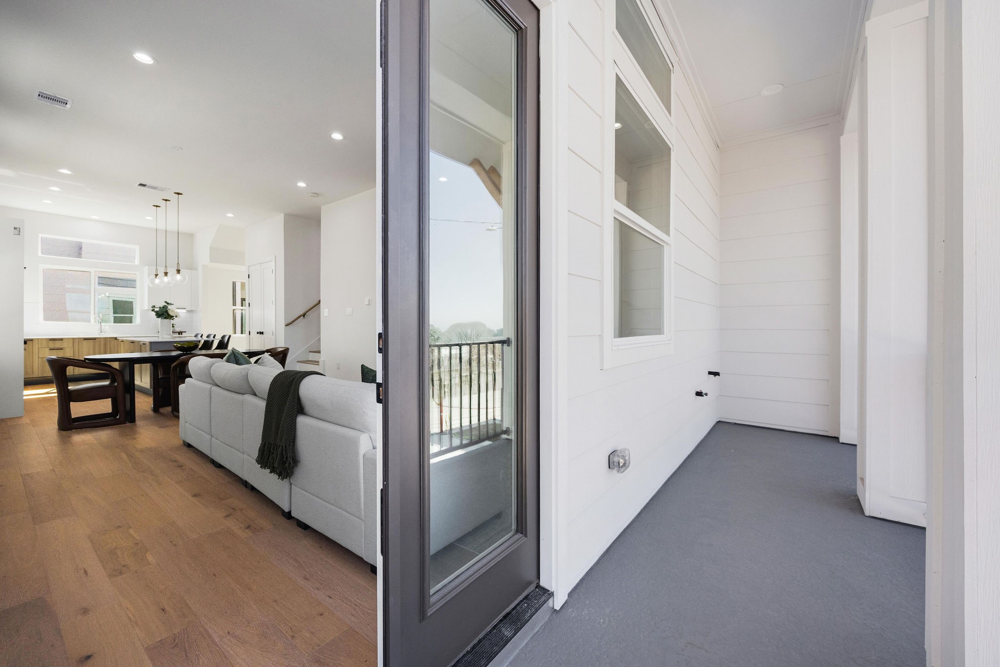 303 Marcella Street, Unit P Houston, TX 77091 - Photo 9 of 26 This photo showcases a modern, open-concept living space with a spacious balcony. Large windows bring in natural light, creating a bright and inviting atmosphere.