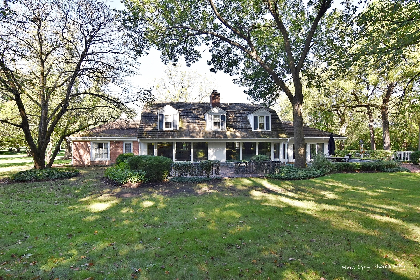 6-n063 Surrey Road Wayne, IL 60184 - Photo 40 of 40 a front view of a house with a garden and trees