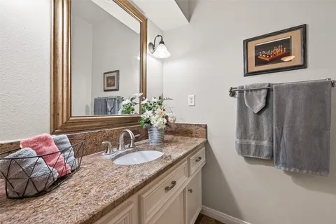 a bathroom with a granite countertop sink a mirror and shower