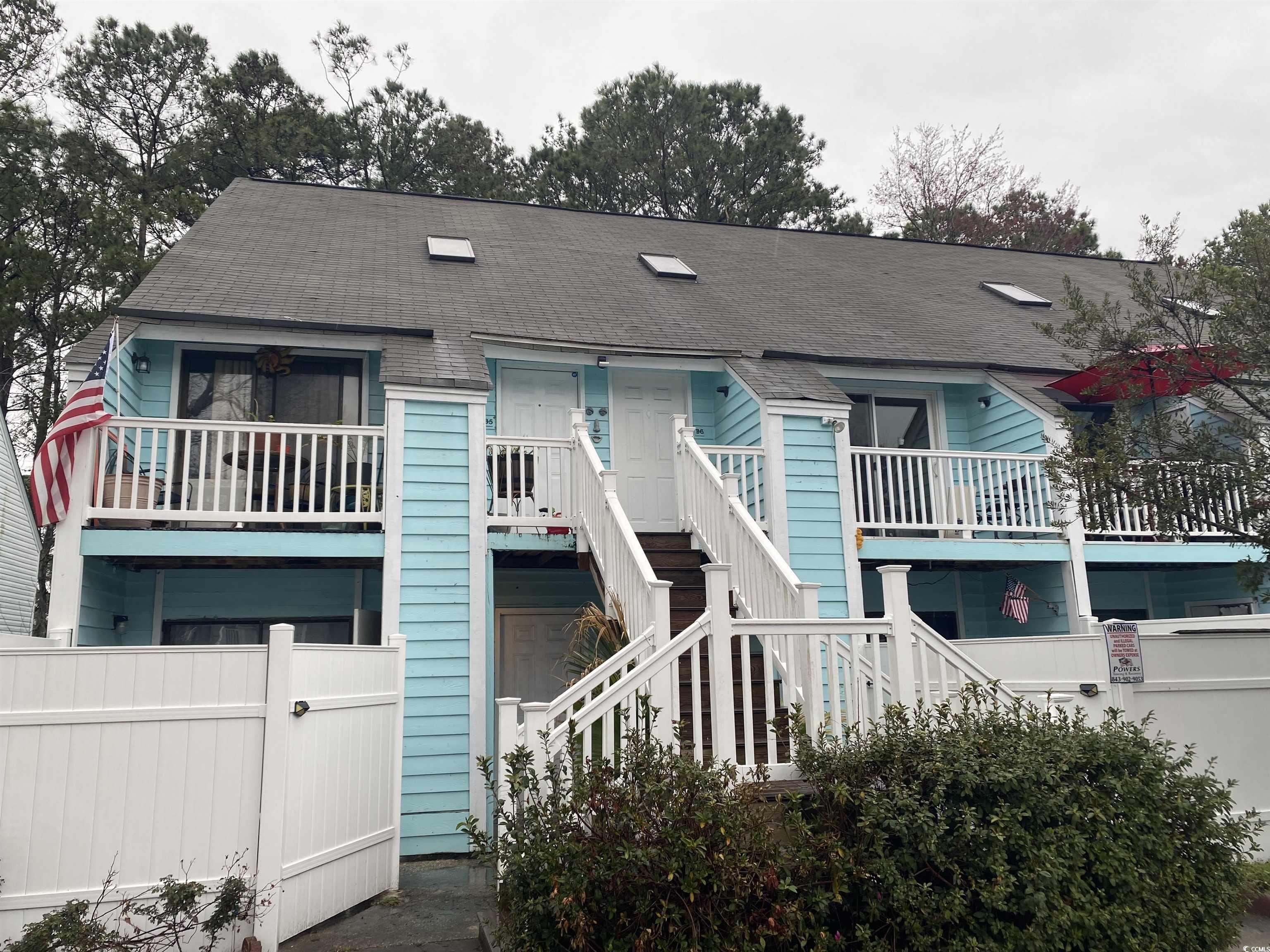 View of front of home with a shingled roof, stairs