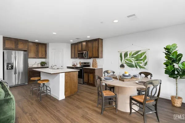 a kitchen with a table chairs refrigerator and microwave