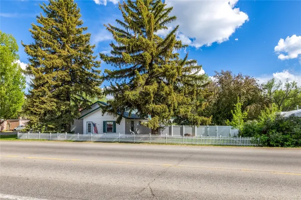 a view of a house with a tree and a yard