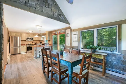 a dining room with furniture window and wooden floor