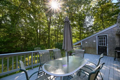 a balcony with wooden floor table and chairs
