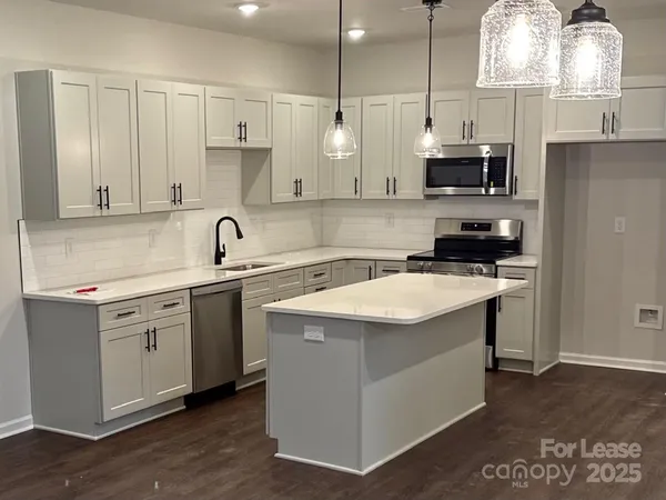 a kitchen with stainless steel appliances granite countertop a sink a stove and a refrigerator