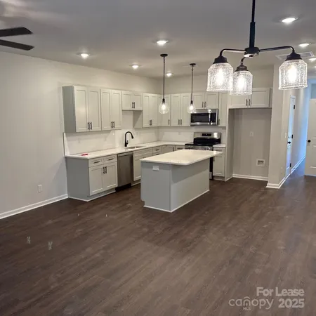 a large kitchen with cabinets wooden floor and stainless steel appliances