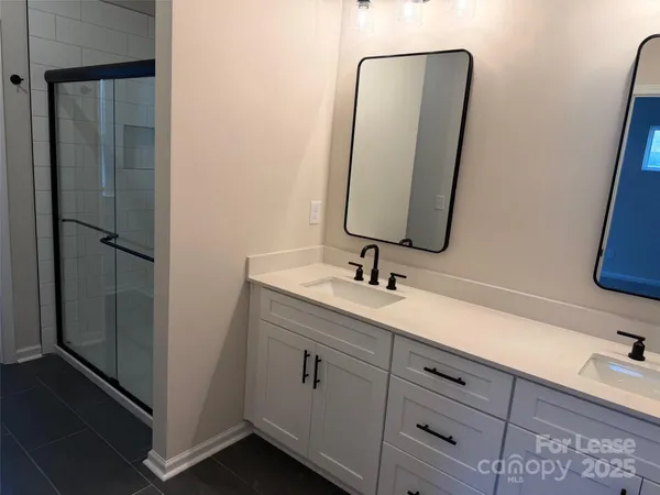 a bathroom with a double vanity sink a toilet and a mirror