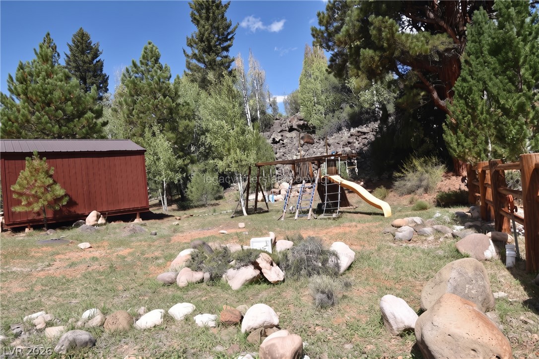 1129 East Ponderosa Road Hatch, UT 84735 - Photo 38 of 47 Towering pines and rocky details frame a spacious mountain yard with a playset.