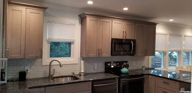 a kitchen with sink a refrigerator and cabinets