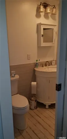 a bathroom with a toilet a sink and mirror