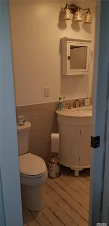 a bathroom with a toilet a sink and mirror