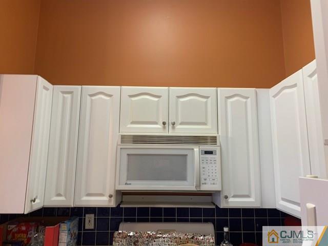 1230 Edpas Road, Unit 1230 New Brunswick, NJ 08901 - Photo 4 of 12 a kitchen with granite countertop a stove and a white cabinet