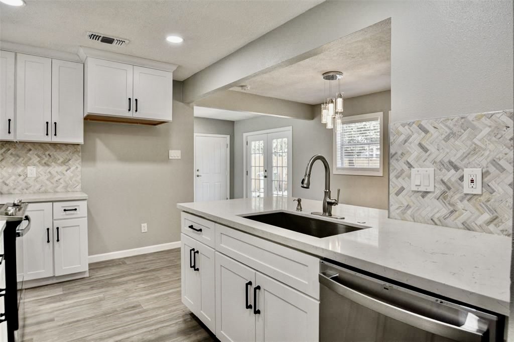 7906 Hammerly Boulevard Houston, TX 77055 - Photo 7 of 22 a kitchen with granite countertop white cabinets and wooden floor