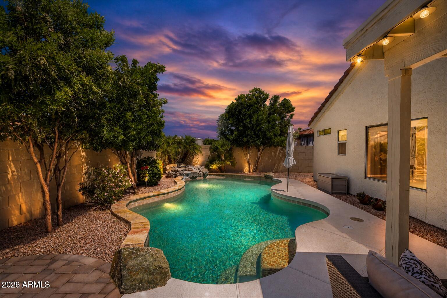 9242 West St John Road Peoria, AZ 85382 - Photo 2 of 59 a view of a backyard with couches plants and large tree