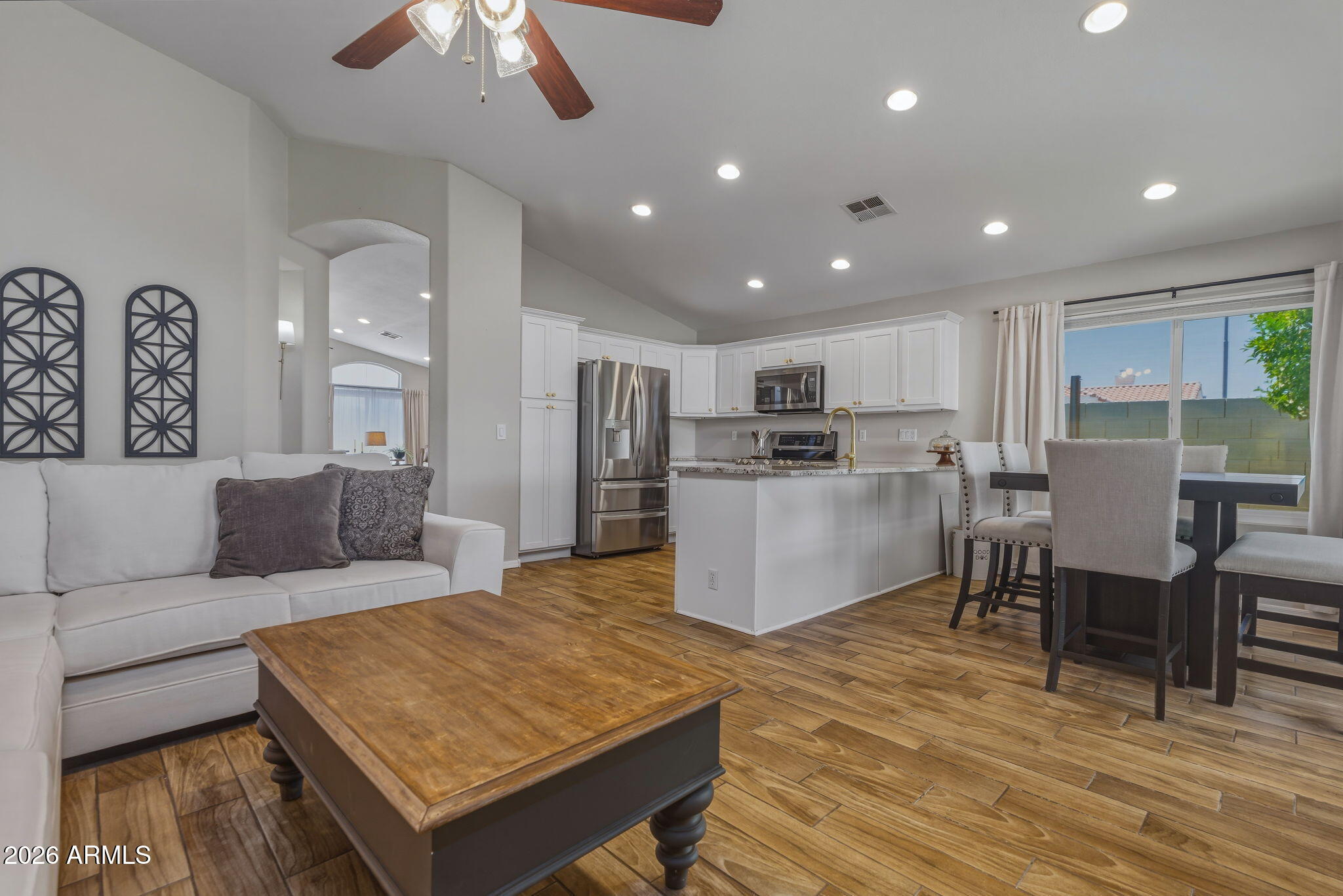 9242 West St John Road Peoria, AZ 85382 - Photo 26 of 59 a living room with stainless steel appliances kitchen island granite countertop furniture wooden floor and a kitchen view
