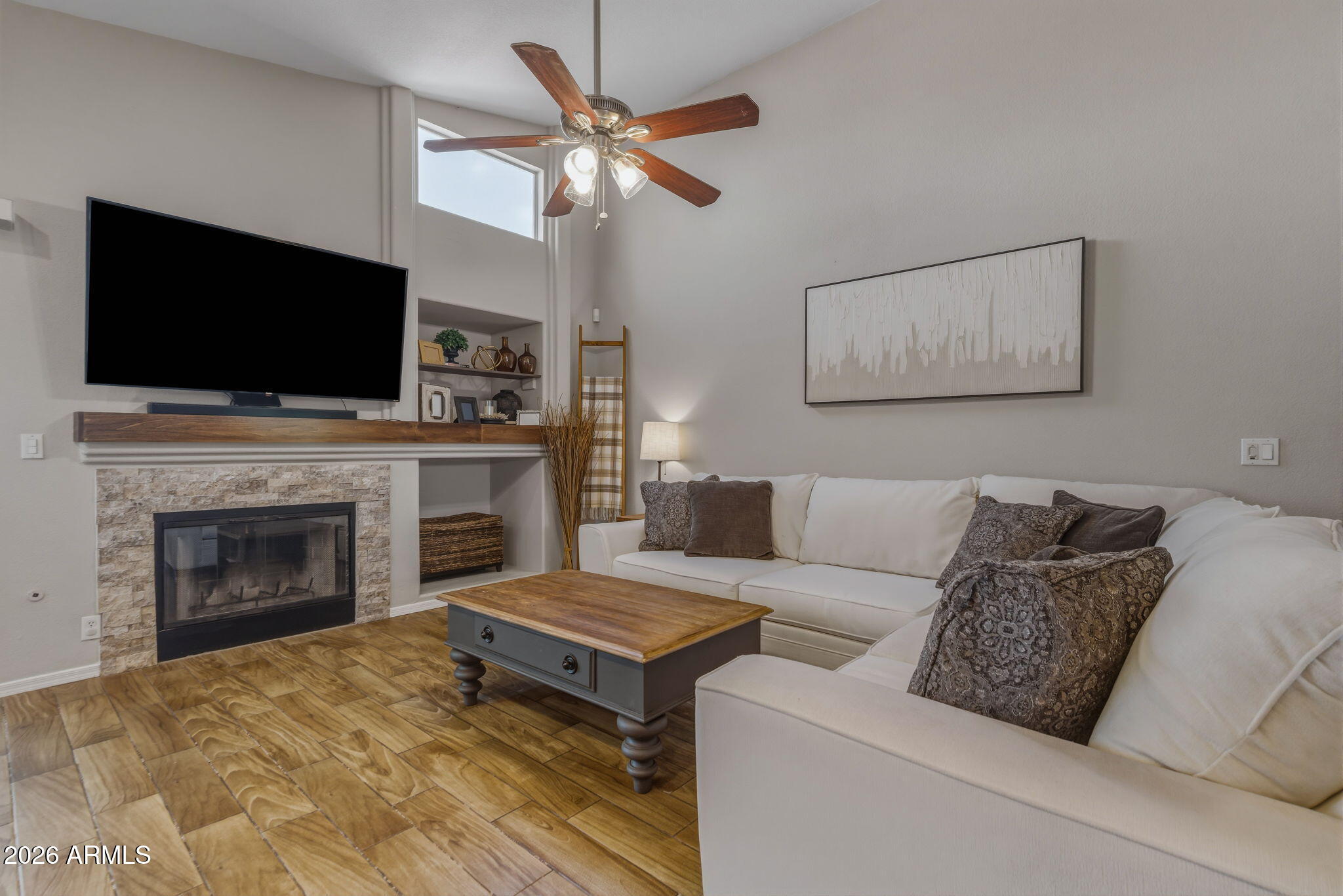 9242 West St John Road Peoria, AZ 85382 - Photo 29 of 59 a living room with furniture a flat screen tv and a fireplace