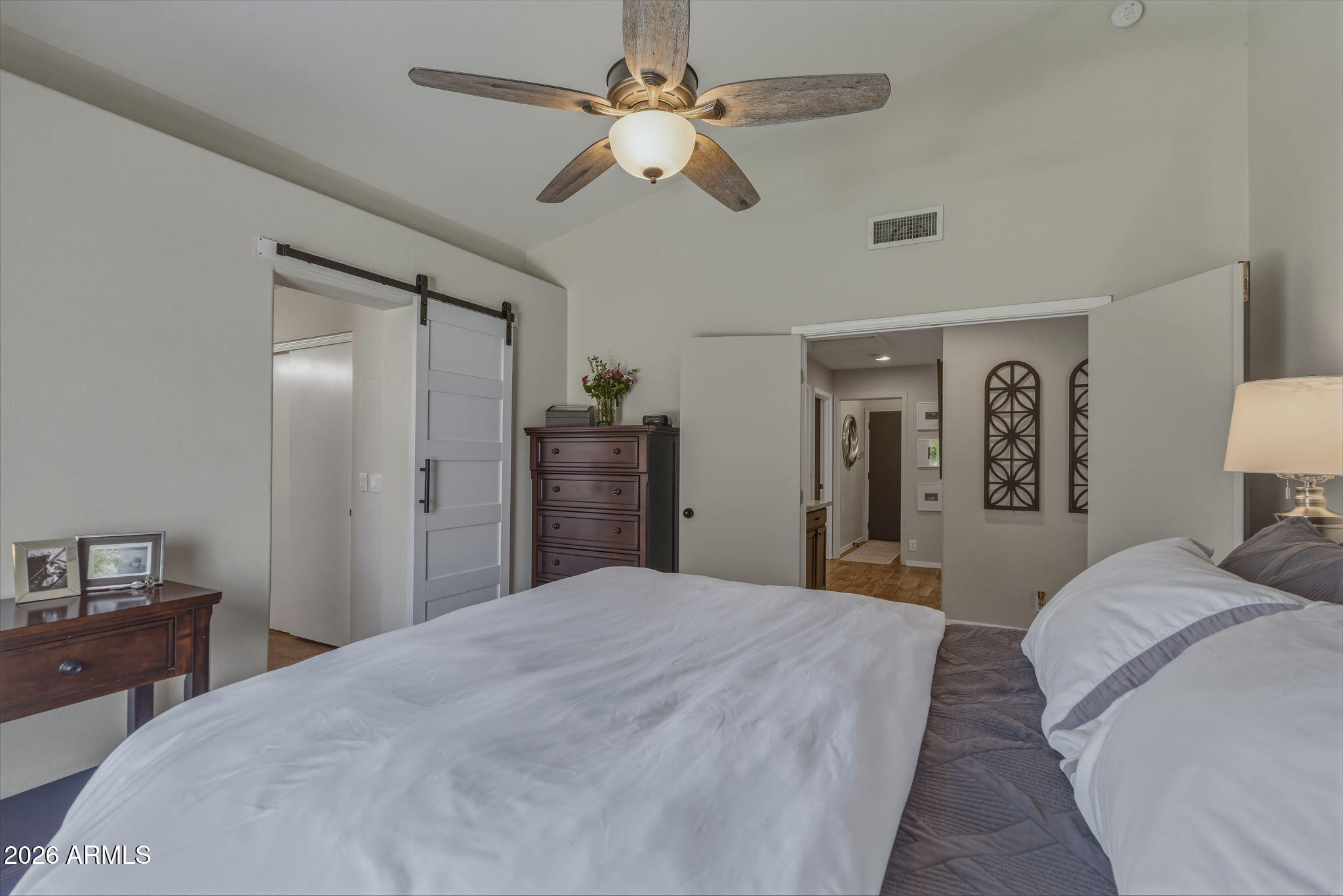 9242 West St John Road Peoria, AZ 85382 - Photo 36 of 59 a bedroom with a large bed and a chandelier