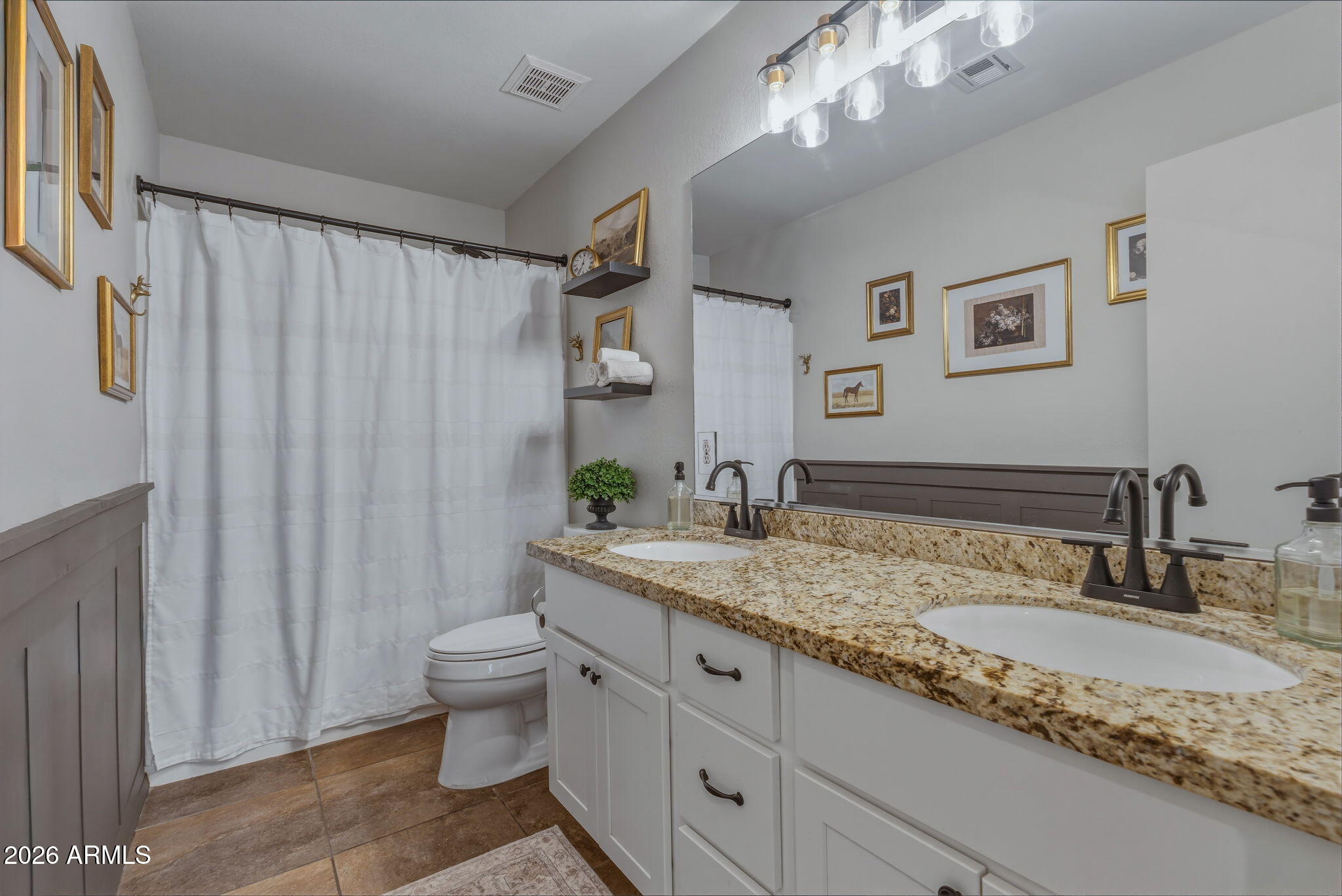 9242 West St John Road Peoria, AZ 85382 - Photo 43 of 59 a bathroom with a granite countertop sink a toilet a mirror and shower curtain