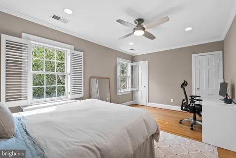 a bedroom with a bed gym equipment and windows