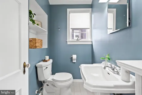 a white toilet sitting next to a bathroom sink