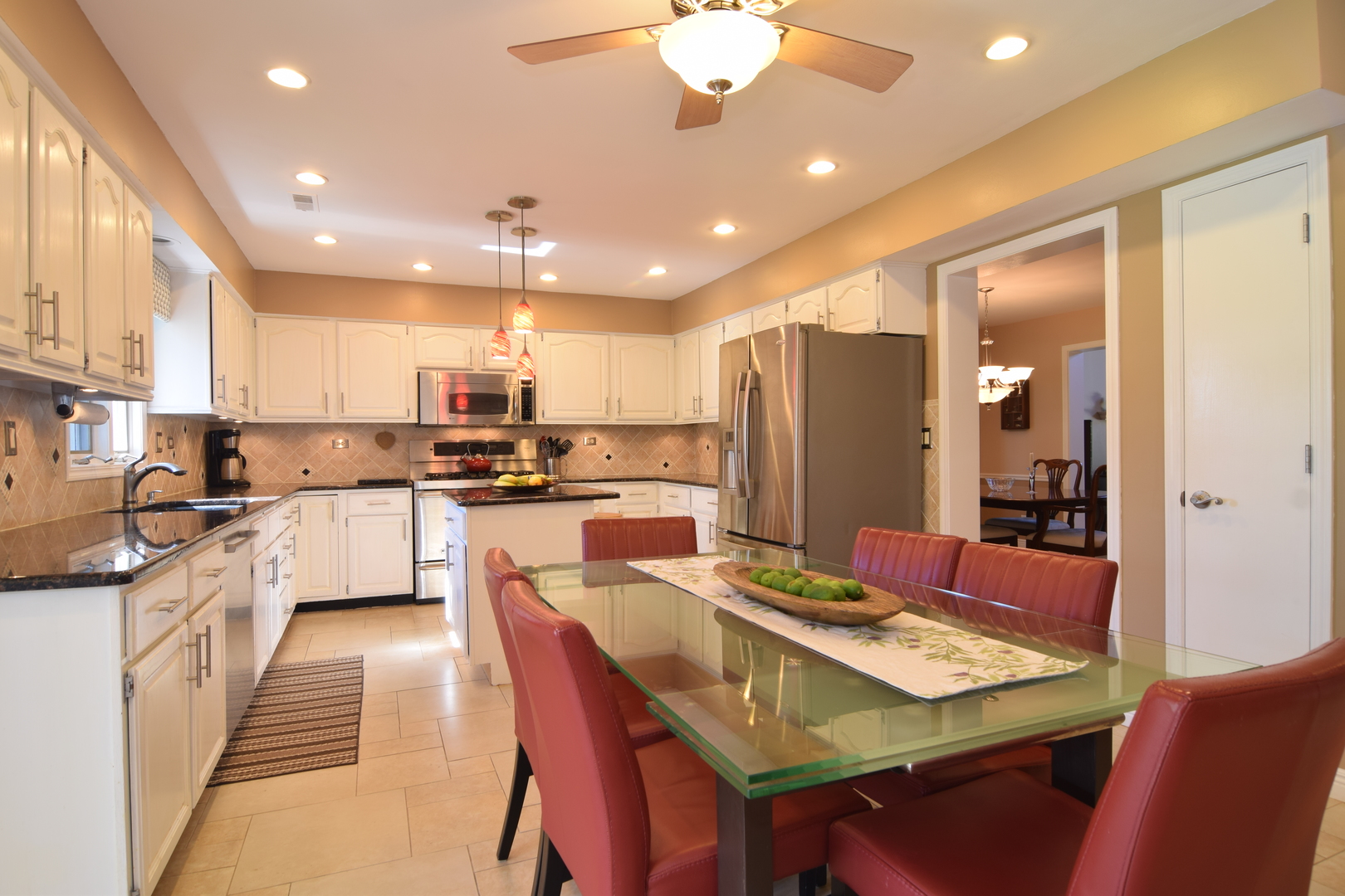1268 Itasca Road Addison, IL 60101 - Photo 4 of 26 a kitchen with stainless steel appliances kitchen island granite countertop a dining table chairs refrigerator sink and cabinets