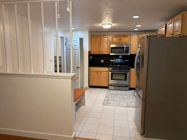a kitchen with stainless steel appliances granite countertop a refrigerator and a stove top oven