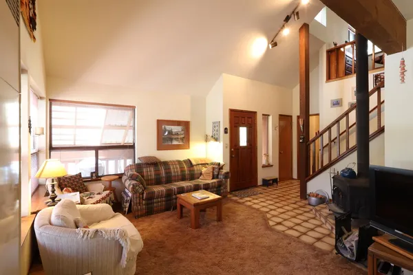 a living room with furniture a large window and a flat screen tv