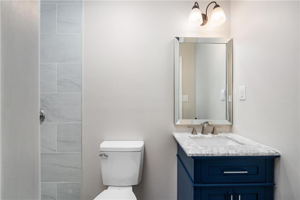 2706 Front Street Monaca, PA 15061 - Photo 11 of 31 a bathroom with a granite countertop sink a toilet and a mirror