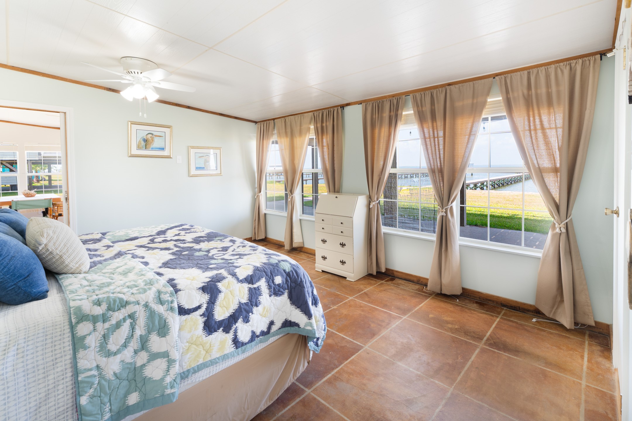 234 El Campo Beach Road Palacios, TX 77465 - Photo 11 of 25 a spacious bedroom with a large bed and a large window