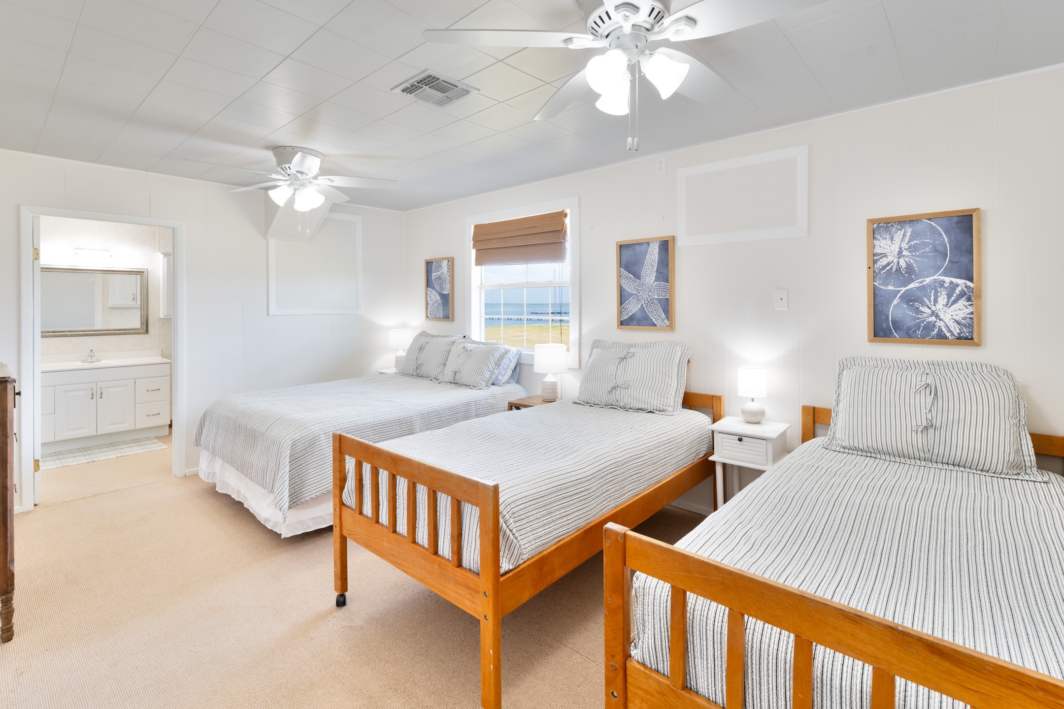 234 El Campo Beach Road Palacios, TX 77465 - Photo 13 of 25 a bedroom with two beds and a chandelier