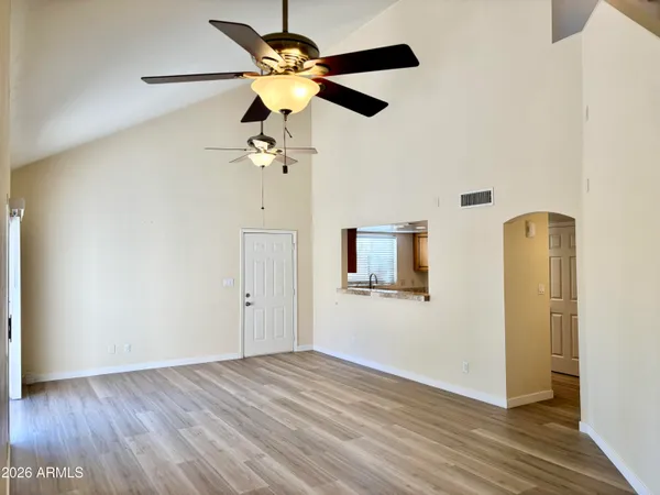 a view of a room with a wooden floor and a ceiling fan