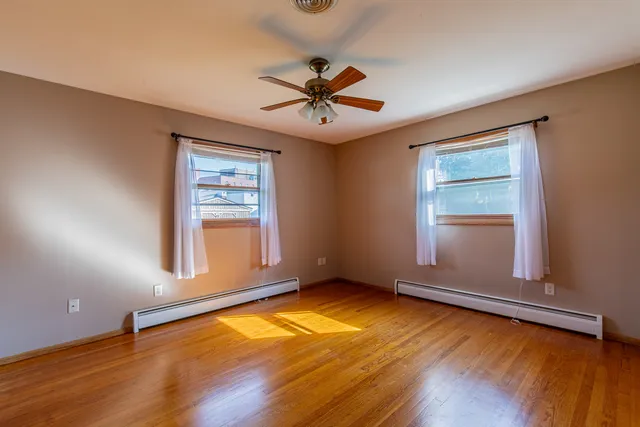 an empty room with a window and wooden floor