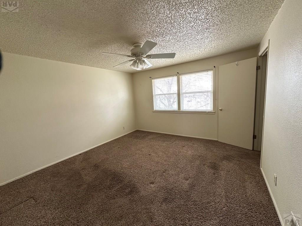1009 Constitution Road Pueblo, CO 81001 - Photo 11 of 11 an empty room with windows and ceiling fan view