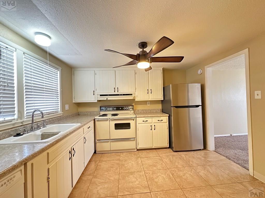 1009 Constitution Road Pueblo, CO 81001 - Photo 3 of 11 a kitchen with a sink appliances and cabinets