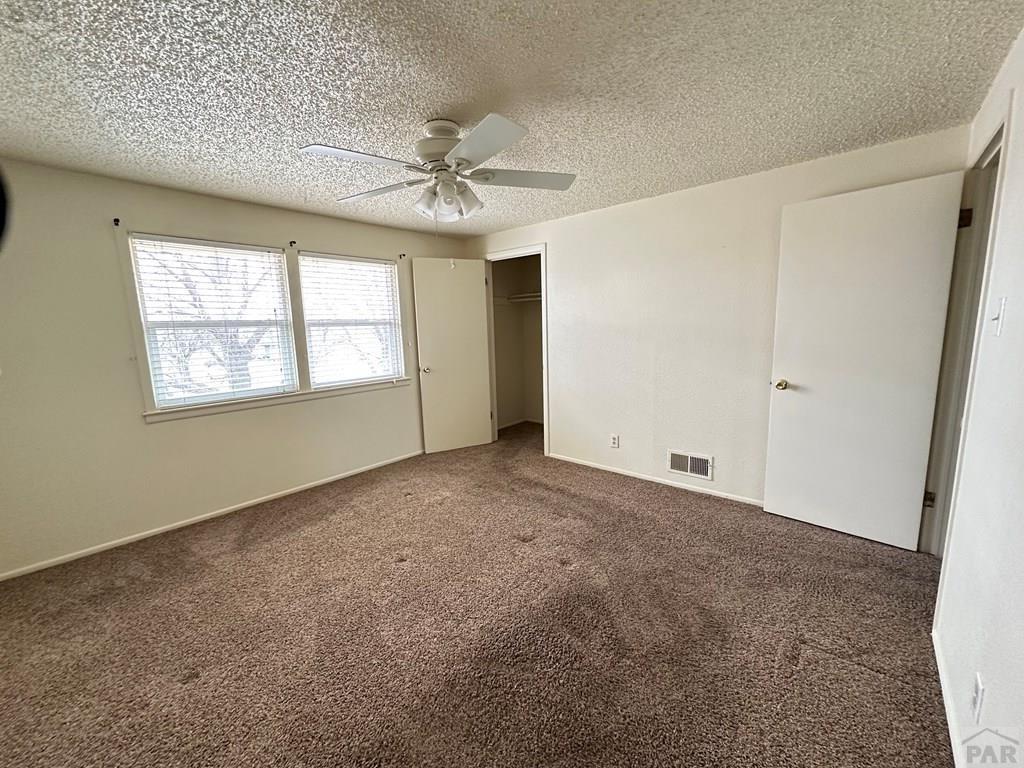 1009 Constitution Road Pueblo, CO 81001 - Photo 7 of 11 an empty room with windows and fan