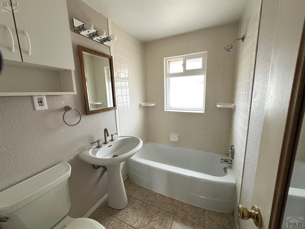 1009 Constitution Road Pueblo, CO 81001 - Photo 9 of 11 a bathroom with a sink toilet and bathtub