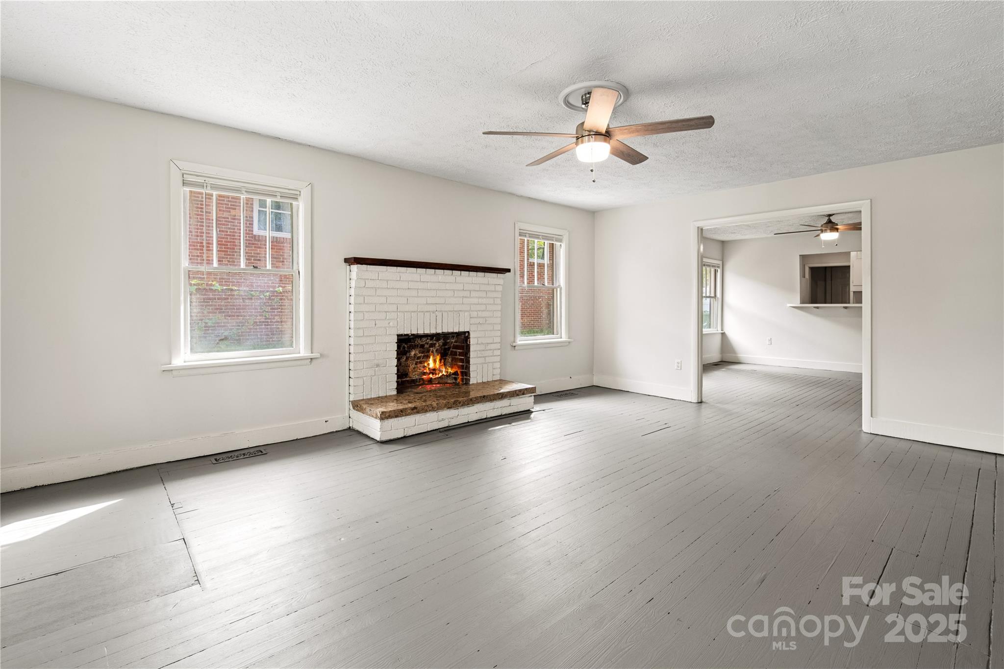 29 Le-An-Hurst Road Asheville, NC 28803 - Photo 3 of 22 a view of a livingroom with a fireplace a ceiling fan and wooden floor