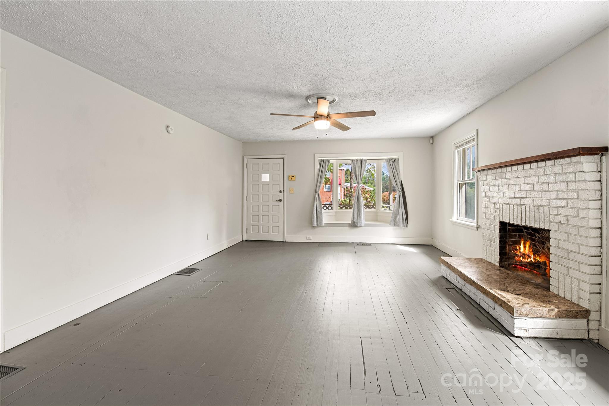 29 Le-An-Hurst Road Asheville, NC 28803 - Photo 4 of 22 an empty room with windows and fireplace