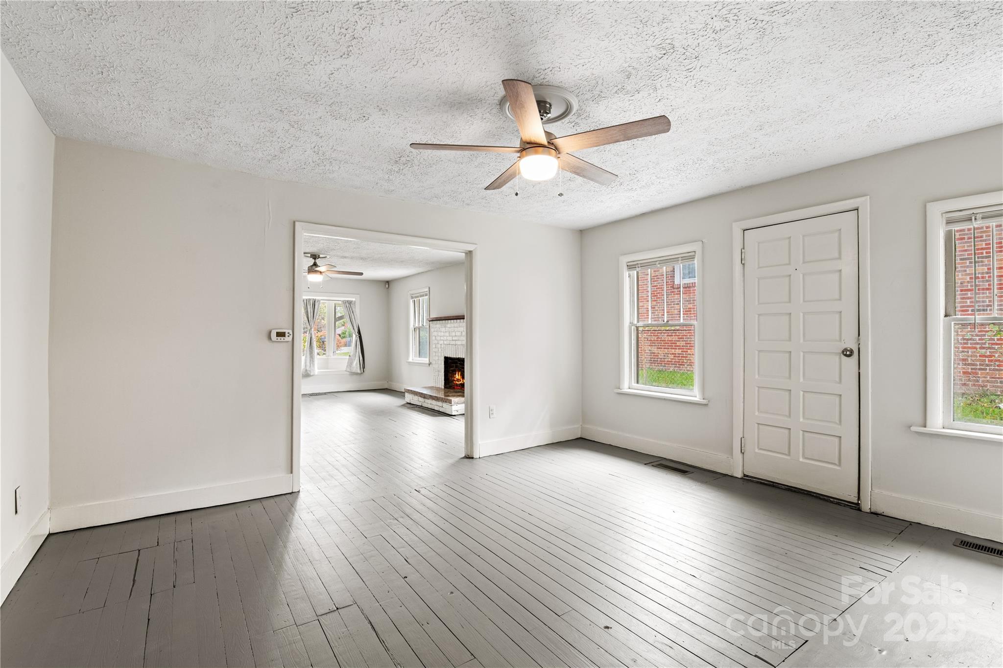 29 Le-An-Hurst Road Asheville, NC 28803 - Photo 7 of 22 an empty room with wooden floor fan and windows