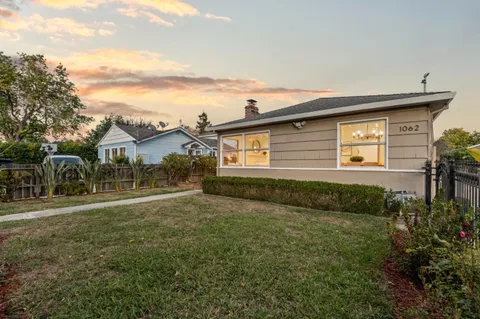 a front view of house with yard and trees around