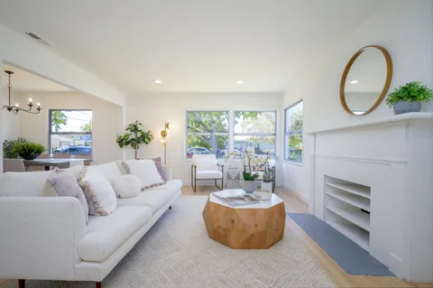 a kitchen with a sink dishwasher stove and white cabinets with wooden floor
